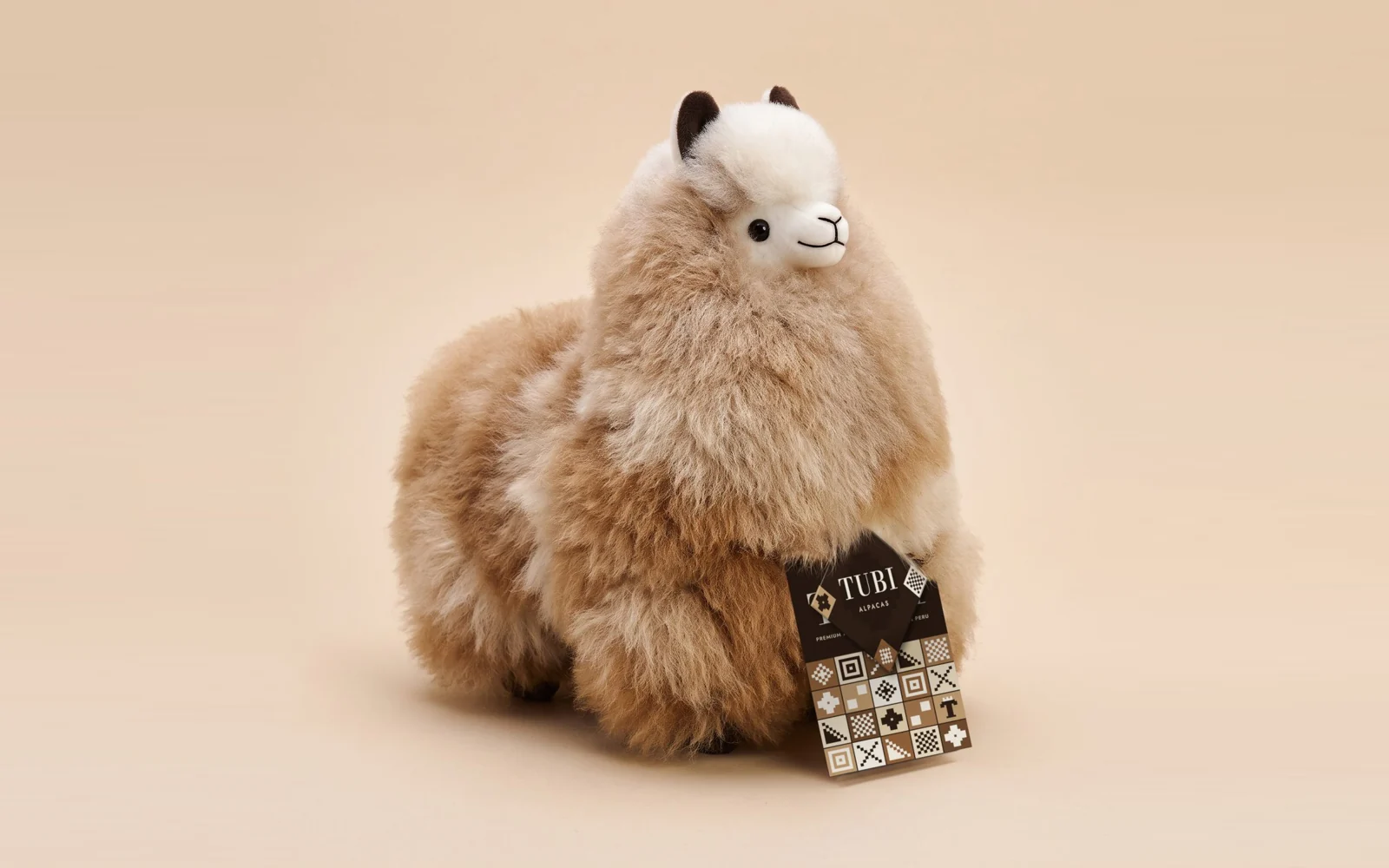 A Small Sandstone alpaca with the Tubi hang tag